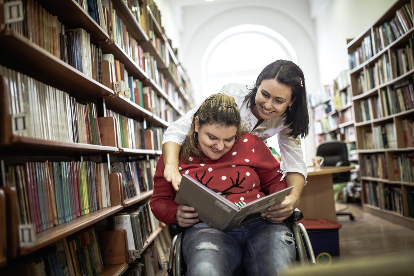 Disabled student visiting library with groupmate